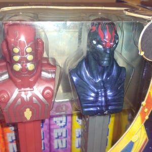 Puede incluir: Un juego empaquetado de dispensadores PEZ con personajes de la pel&iacute;cula Marvel Eternals. Los dispensadores incluyen figuras rojas y azules con dise&ntilde;os detallados y paquetes de caramelos coloridos.