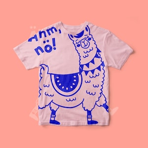 May include: A pale pink t-shirt with a blue llama design. The llama has a saddle and a decorative collar. The text "Ahm, nö!" is printed in blue on the top left of the shirt.