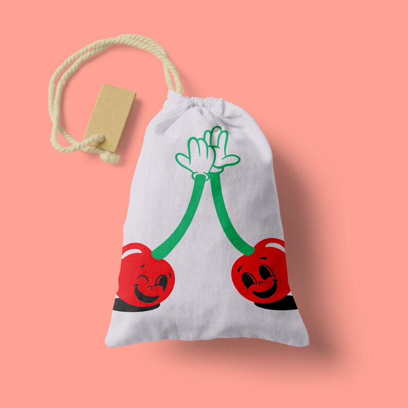 Peut inclure: Un sac en toile blanc avec un motif de cerises rouges et vertes. Les cerises ont des visages souriants et se donnent une tape dans la main.