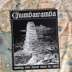 Könnte beinhalten: Schwarz-weißes Albumcover mit dem Bandnamen "Chumbawamba" in gotischer Schrift. Das Bild zeigt eine detaillierte Illustration eines hohen, sich windenden Turms. Der Text "nothing ever burns down by itself" steht unten.