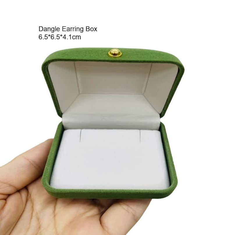 May include: Open green velvet dangle earring box with a white interior. The box is rectangular, with a gold-colored clasp. Text on the image reads: Dangle Earring Box 6.5*6.5*4.1cm.