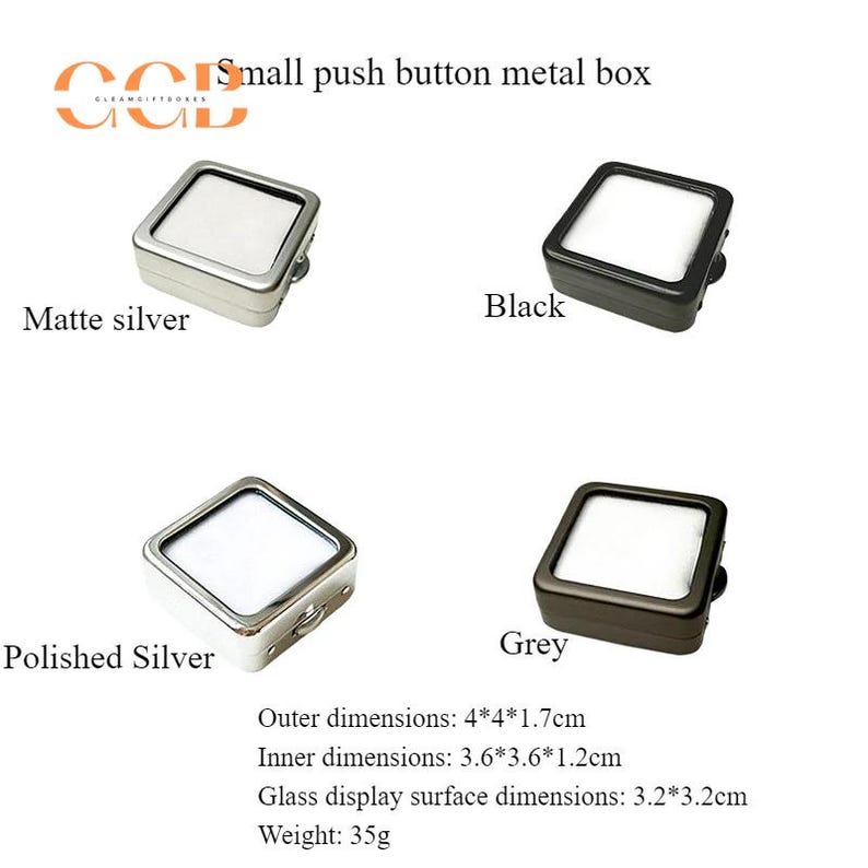 K&ouml;nnte beinhalten: Vier kleine, quadratische Metallboxen in mattem Silber, poliertem Silber, Schwarz und Grau. Jede Box hat eine transparente Displayoberfl&auml;che. Der Text auf dem Bild lautet "Small push button metal box". Au&szlig;enma&szlig;e: 4*4*1,7 cm.