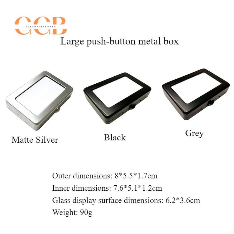 K&ouml;nnte beinhalten: Drei Metall-Ausstellungsboxen mit Druckknopfverschl&uuml;ssen in mattem Silber, Schwarz und Grau. Au&szlig;enma&szlig;e: 8cm x 5.5cm x 1.7cm. Innenma&szlig;e: 7.6cm x 5.1cm x 1.2cm. Glas-Ausstellungsfl&auml;che: 6.2cm x 3.6cm. Gewicht: 90g.