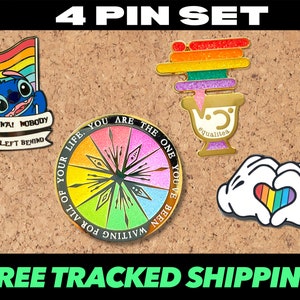 Può includere: Set di quattro spille smaltate con uno schema di colori arcobaleno. Le spille includono un personaggio di Stitch con il testo "Ohana! Nobody gets left behind", una ruota arcobaleno con il testo "For all of your life. You are the one you've been waiting for", una pila di blocchi arcobaleno con il testo "@qualites", e un paio di mani di Topolino che formano un cuore con un cuore arcobaleno al suo interno.