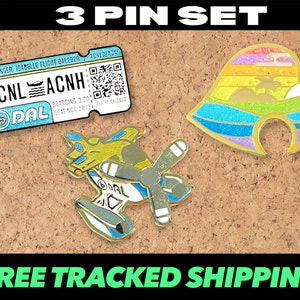 May include: A set of three gold-colored enamel pins featuring a rainbow-colored leaf, a plane, and a blue and white airline ticket with the text "ACNL ACNH DAL".
