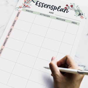May include: A weekly meal planner with a floral design. The planner has columns for breakfast, lunch, dinner, and snacks. The days of the week are listed on the left side of the planner.