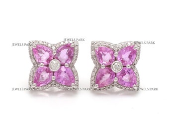 Può includere: Un paio di orecchini a forma di fiore con zaffiri rosa e diamanti incastonati in oro bianco.