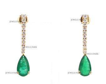 May include: A pair of emerald and diamond drop earrings. The earrings feature a pear-shaped emerald gemstone and a line of round brilliant diamonds.
