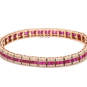 Pode incluir: Uma pulseira de ténis de ouro rosa com uma fila de rubis de corte almofada e uma fila de diamantes menores. A pulseira é feita de ouro rosa de 14 quilates e tem um fecho seguro.