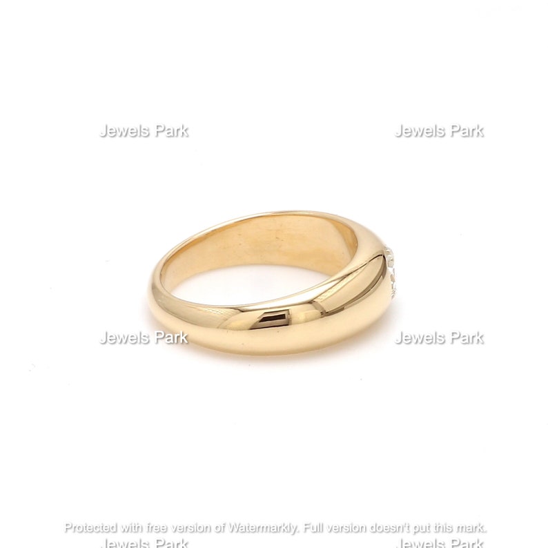 May include: A gold band ring with a row of small diamonds set into the top of the band.