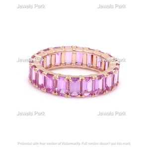 May include: A rose gold eternity band ring with a row of pink rectangular gemstones.