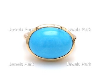 May include: A gold ring with a large oval turquoise gemstone.