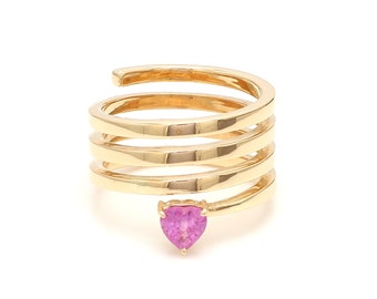 May include: A gold ring with a pink heart-shaped gemstone. The ring is made of multiple bands that are twisted together to create a spiral effect.