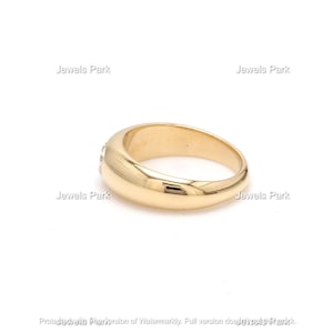 May include: A gold band ring with a row of small clear stones set into the band.
