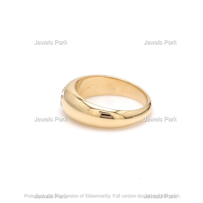 May include: A gold band ring with a row of small clear stones set into the band.