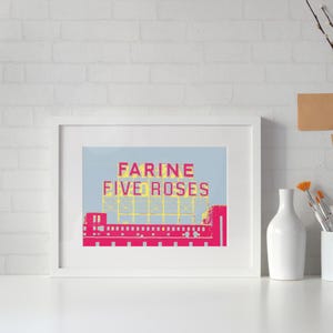 Peut inclure: Une impression encadrée d'un bâtiment avec une enseigne qui dit "Farine Five Roses" en lettres roses et jaunes sur un fond bleu clair.