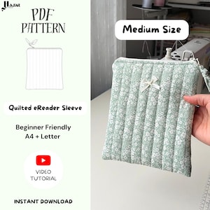 Puede incluir: Una funda acolchada para lector electrónico de tamaño mediano con un estampado floral verde claro. La funda tiene un lazo blanco y un cierre de cremallera. La imagen también muestra el texto "PDF Pattern", "Quilted eReader Sleeve" y "Beginner Friendly A4 + Letter".