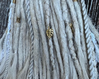 A set of long and thick gray dreadlocks with gold and silver beads and charms