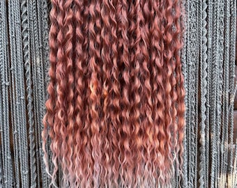 Curly hair extensions with a gradient color from a reddish-brown to light bronze, long auburn dreads extensions, mix of light brown and red