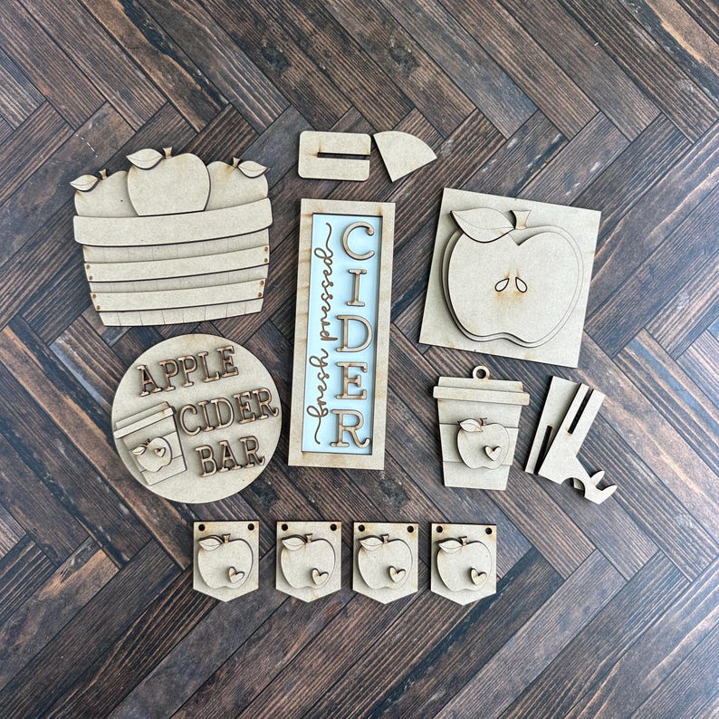 Puede incluir: Kit de artesan&iacute;a de madera para una barra de sidra de manzana. El kit incluye un letrero que dice "Sidra reci&eacute;n prensada", un letrero redondo que dice "Barra de sidra de manzana", una cesta de manzanas, una taza con una manzana y cuatro banderas de manzana.