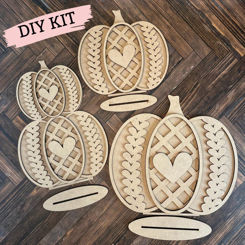 May include: DIY kit featuring three unfinished wooden pumpkin cutouts. Each pumpkin has a heart and lattice design and is layered for a 3D effect. The pumpkins are ready to be painted and decorated.