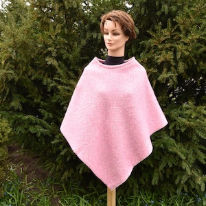 Peut inclure: Un poncho en tricot rose avec un motif géométrique. Le poncho est fait d'un matériau doux et chaud, parfait pour les superpositions pendant les mois les plus froids.