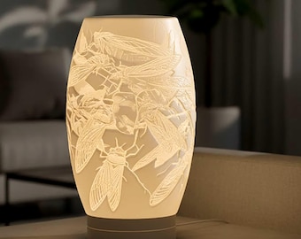 May include: A cream-colored, oval-shaped lamp with a detailed relief of cicadas. The lamp sits on a gray base and emits a soft, warm glow. The intricate insect design adds a unique touch to this decorative lighting fixture.