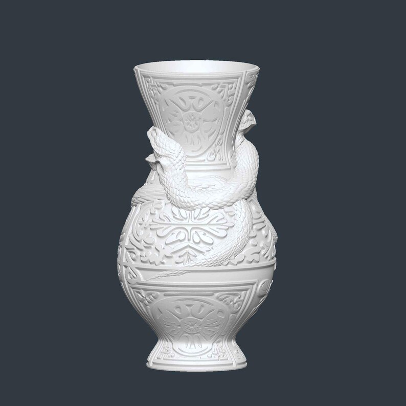 May include: White decorative vase with a detailed relief pattern and two snakes coiled around the body. The vase has a flared top and a pedestal base. The design features floral and geometric elements.