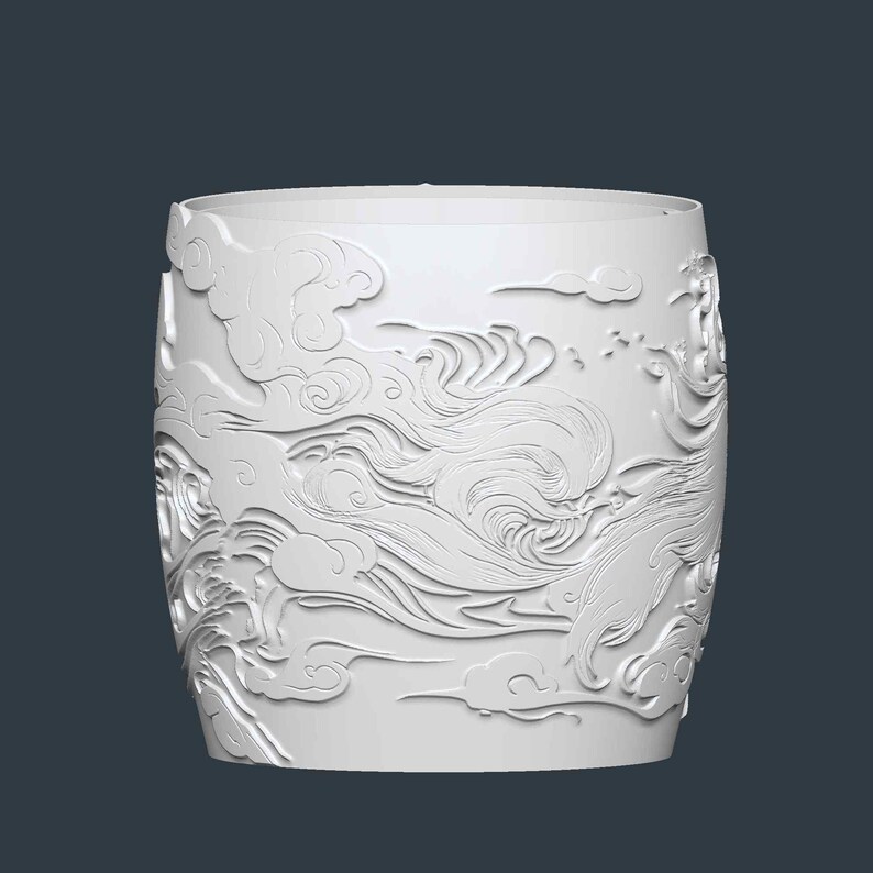 Puede incluir: Un recipiente cil&iacute;ndrico blanco con un intrincado dise&ntilde;o en relieve de nubes y l&iacute;neas fluidas. El dise&ntilde;o envuelve toda la superficie, creando una apariencia texturizada y art&iacute;stica. El recipiente tiene un borde superior liso y sin adornos.