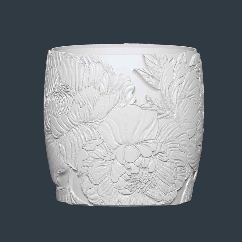 Peut inclure: Un r&eacute;cipient cylindrique blanc avec un motif floral en relief. La sculpture d&eacute;taill&eacute;e pr&eacute;sente de grandes fleurs de pivoines et des feuilles, cr&eacute;ant une surface textur&eacute;e. Le r&eacute;cipient a un bord et une base lisses et sans ornements.