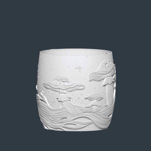 May include: White cylindrical glass with an embossed design of mushrooms and flowing lines. The design includes three mushrooms of varying sizes, with a star and small dots scattered around the scene. The glass has a smooth, unadorned rim.