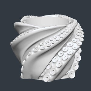 May include: A white, stylized octopus-tentacle-shaped object. The design features a spiraling form with detailed suckers along the edges, creating a unique and artistic appearance. The object is set against a dark gray background.