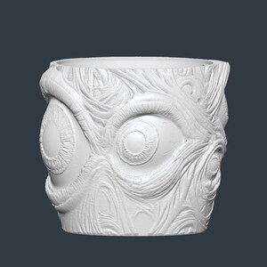 May include: White, cylindrical plant pot with a textured surface featuring multiple eye designs. The pot has a wide opening and is made of a solid, opaque material. The design is detailed and appears to be carved or moulded.