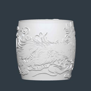 Puede incluir: Un recipiente cil&iacute;ndrico blanco con un dise&ntilde;o en relieve de una criatura m&iacute;tica, posiblemente un drag&oacute;n o un f&eacute;nix, en medio de nubes arremolinadas. El relieve envuelve toda la superficie, creando un efecto tridimensional.