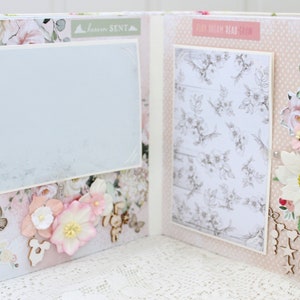 May include: A scrapbook page with a light blue background and floral embellishments. The page has a white frame with a light blue background and the text "Dream Read Relax" in a pink font. The page also has a white frame with a light blue background and the text "Forever Sent" in a pink font.