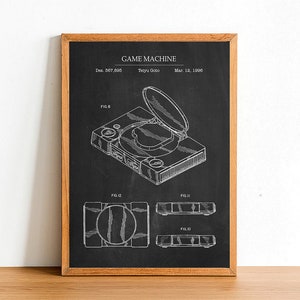 May include: A black and white technical drawing of a game machine patent. The drawing shows a top-down view of the game machine with the disc drive open. The patent is titled "GAME MACHINE" and includes the inventor's name, "Tetyru Goto", and the date, "Mar. 12, 1996".
