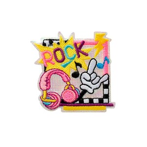 Könnte beinhalten: Ein gestickter Aufnäher mit einem gelben Sternenburst und dem Wort ROCK in lila und pinken Buchstaben. Er enthält einen pinken Kopfhörer, eine weiße behandschuhte Hand mit Rock-Geste, eine blaue Musiknote sowie einen schwarz-weißen Rand.