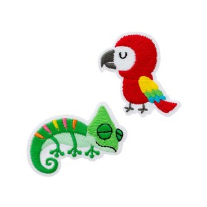 Op de afbeelding: Twee geborduurde patches met een rode papegaai met gele en blauwe vleugelaccenten en een groene kameleon met oranje en roze strepen op de rug. Beide dierenfiguren zijn afgebeeld in een cartoonstijl met gesloten ogen.