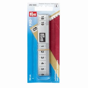 Peut inclure: Un ruban à mesurer autocollant Prym FIXO blanc dans son emballage de vente bleu et rouge. Le ruban présente des marquages numériques noirs et mesure 150 cm de longueur totale. L'emballage affiche le code produit 282 690 et la catégorie de prix L.