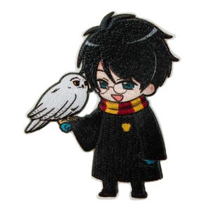 Peut inclure: Un écusson brodé représentant un personnage de dessin animé aux cheveux noirs et lunettes rondes, portant une robe noire avec une écharpe rayée jaune et rouge. Le personnage tient un hibou blanc sur une main, avec un petit écusson jaune.