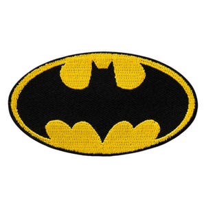 Può includere: Una toppa ricamata di forma ovale con una silhouette di pipistrello nera centrata su uno sfondo giallo vibrante, racchiusa da un bordo giallo spesso. Il design è cucito con una trama di filo densa, creando un aspetto rialzato e resistente.
