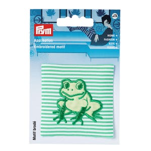 May include: A square fabric patch featuring a light green embroidered frog on a white and green striped background. The patch is attached to a Prym brand retail card with the text Applikation, Embroidered motif, Motif brodé, HOME, FASHION, KIDS, TEENS.