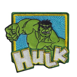 Puede incluir: Un parche bordado cuadrado que muestra a un personaje de cómic verde con el puño cerrado, sobre un fondo azul con un borde amarillo. La palabra HULK está bordada en letras blancas grandes con un contorno amarillo en la parte inferior.