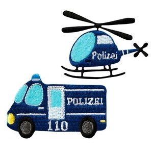 Può includere: Due toppe ricamate raffiguranti un elicottero della polizia blu con rotori neri e la scritta Polizei, e un furgone della polizia blu con finestrini azzurri, la scritta Polizei e il numero 110 in filo bianco, su uno sfondo bianco.
