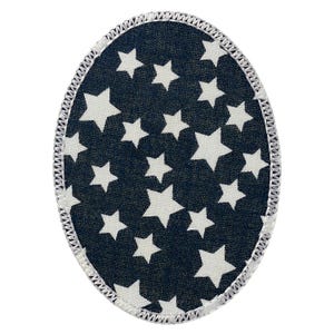May include: An oval-shaped fabric patch featuring a dark navy blue background with a repeating pattern of white five-pointed stars. The entire perimeter of the patch is finished with a thick, white, overlock-stitched embroidered border.