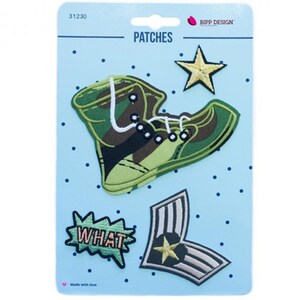 May include: A set of three embroidered patches on a light blue backing card. The patches include a camouflage high-top sneaker, a gold star, a green speech bubble with the text WHAT, and a grey chevron-style military rank patch with a star.