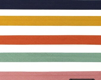 May include: Five horizontal strips of bias tape in navy blue, mustard yellow, burnt orange, sage green, and dusty pink. Each strip features a central fold line. A small black rectangular label in the bottom right corner displays the text 23 Farben.