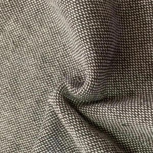 May include: A close-up view of a woven fabric featuring a dense, textured pattern of dark charcoal gray and off-white threads. The material is folded, creating soft, undulating curves that highlight the intricate, uniform weave of the textile.