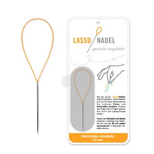 Op de afbeelding: Een zilveren naainaald met een grote, flexibele oranje lus aan het oog, gepresenteerd op een witte kartonnen kaart met de tekst LASSO NADEL, een gebruiksdiagram en de specificatie van 0,5 mm dikte.