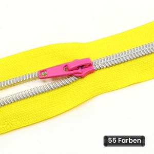 May include: A bright yellow zipper featuring silver-colored metal teeth and a vibrant pink slider pull. The zipper tape is made of a woven fabric material. A small black rectangular label in the corner displays the text 55 Farben.